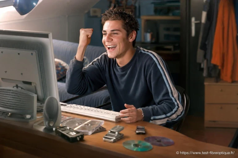 Jeune homme heureux devant ordinateur